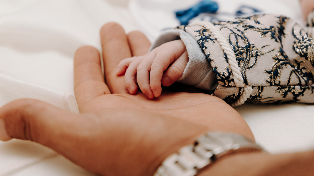 Father holding baby's hand for Fathers Day blog