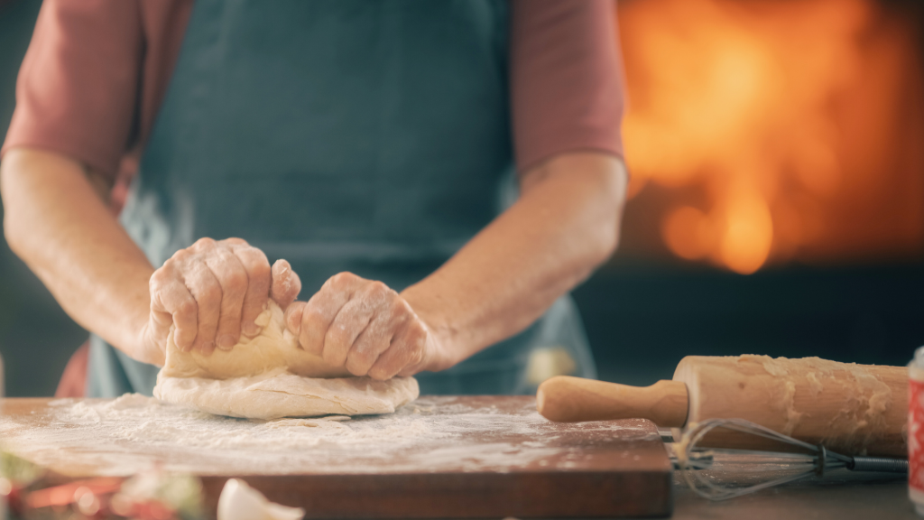 Close-up of hands rolling pastry dough, symbolising homemade winter comfort food. The image evokes cosy, sustainable cooking practices discussed in the blog.